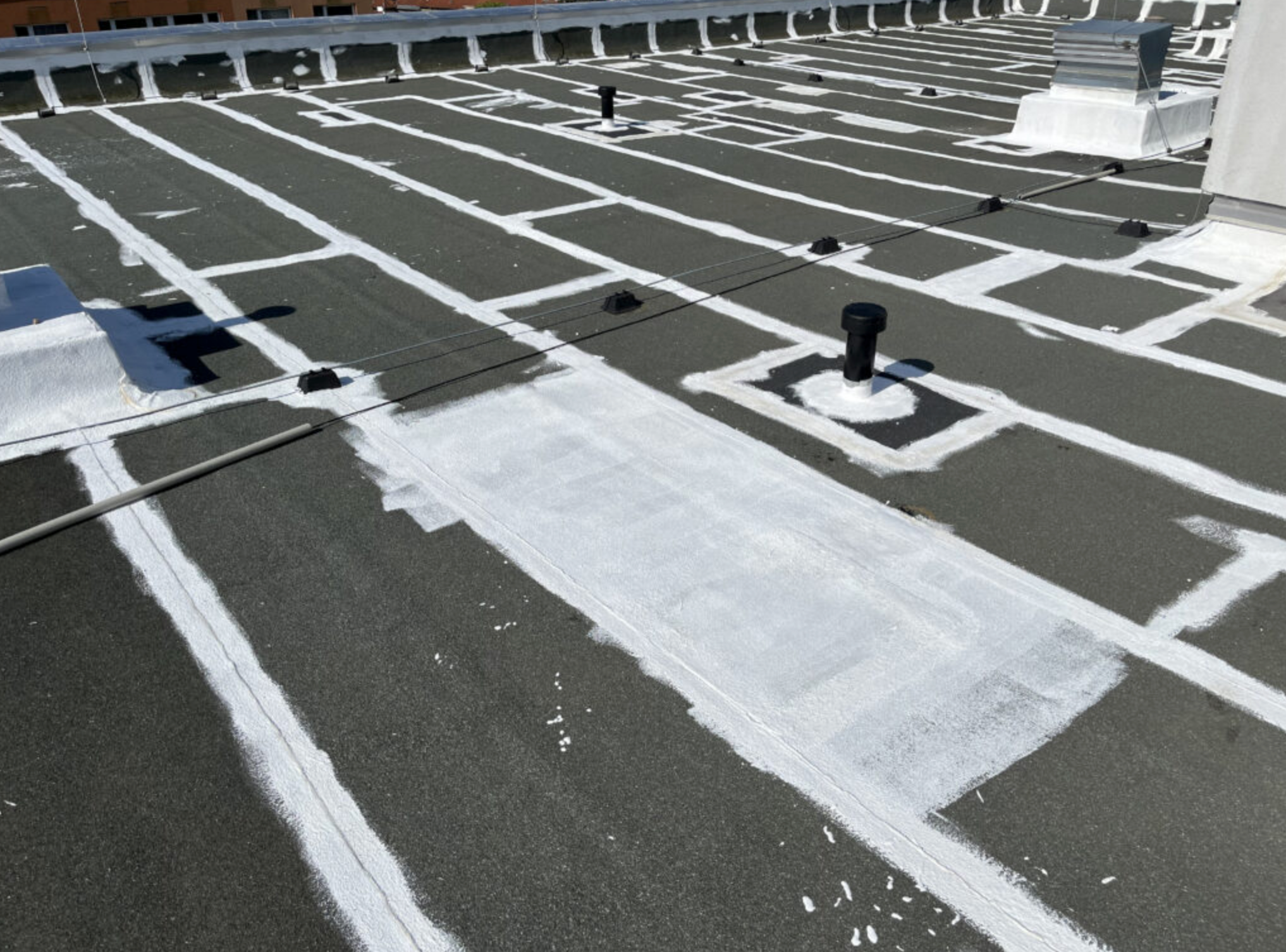 Detail aplikace reflexně izolačního nátěru na plochou střechu